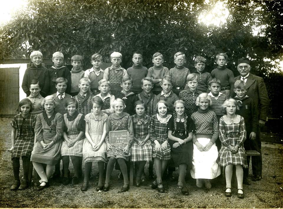 Fotografen er Kaare Rasmussen, Rønne. På tavlen, som pigen i midten har på skødet står: "Øm. n. Skole, III Klasse, 1936. (Østermarie nordre Skole). Skolebilledet har tilhørt H.V. Jørgensen, som sikkert er en af drengene på billedet. Bornholms Ø-arkiv.